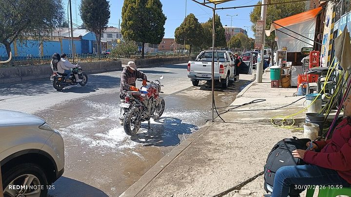 Motocicleta sendo lavada com cuidado na parte elétrica